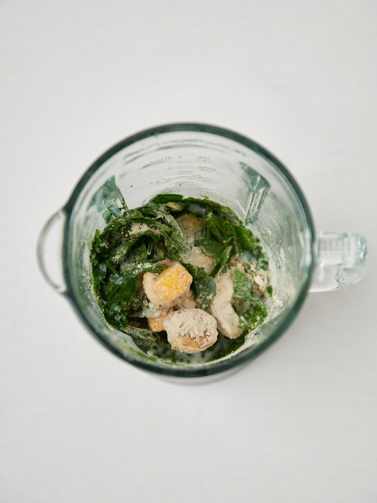 smoothie mixer von oben mit spinat mango und banane

