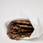 Homemade seed crackers wrapped in parchment paper.