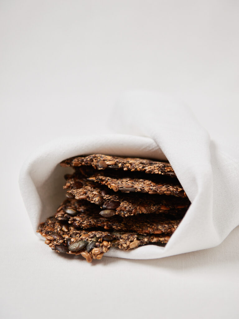 Homemade seed crackers wrapped in parchment paper.