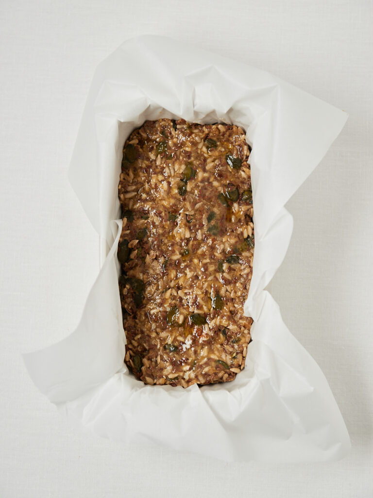 Ungebackene Life-Changing-Bread-Masse in einer mit Backpapier ausgelegten Kastenform, bereit für den Ofen.