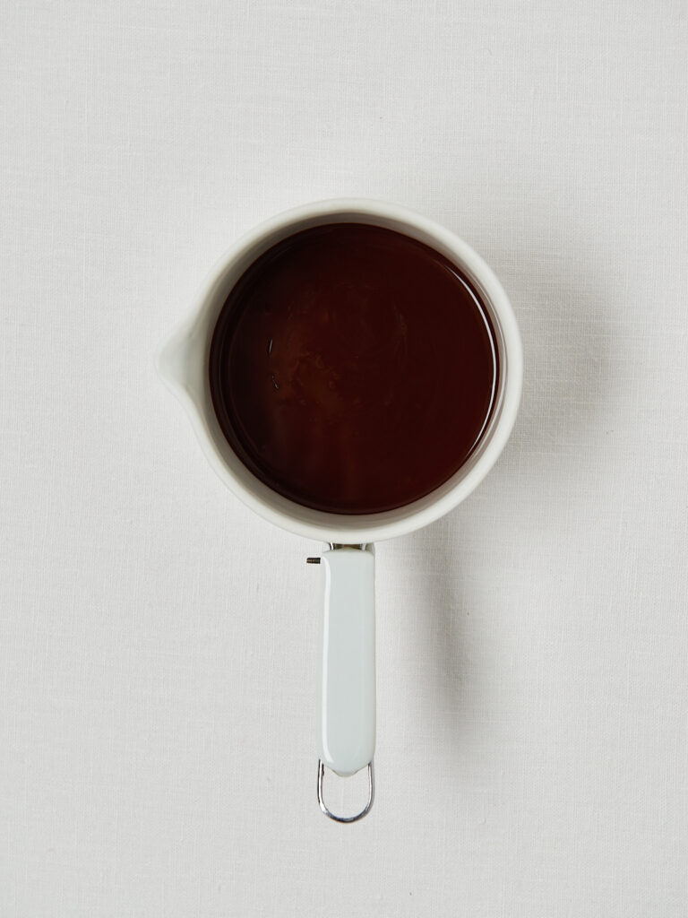 Schokolade schmelzen, Haselnussmus einrühren und cremige Schokomasse vorbereiten – drei Prozessbilder in Messbechern.