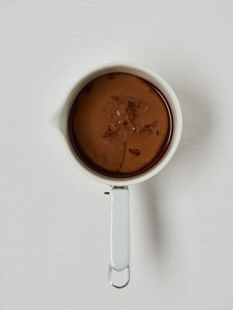 Schokolade schmelzen, Haselnussmus einrühren und cremige Schokomasse vorbereiten – drei Prozessbilder in Messbechern.