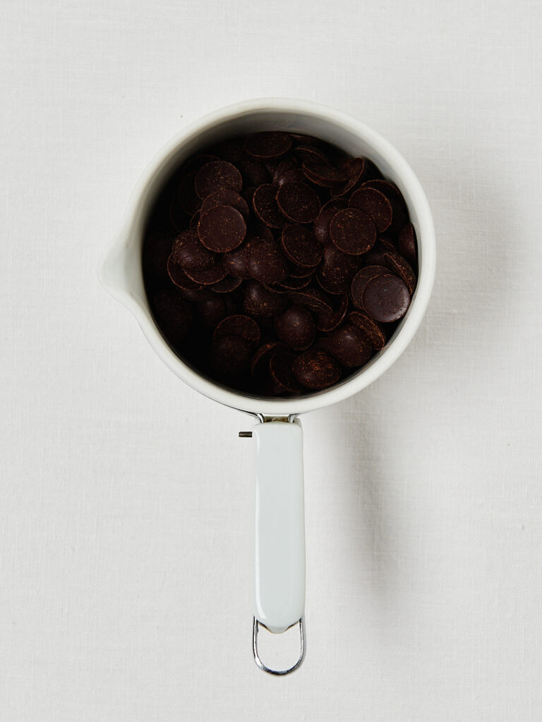 Drei Schritte zur Fudge-Basis: Schokodrops in einem Messbecher, geschmolzene Schokolade und geschmolzene Schokolade mit Erdnussmus.