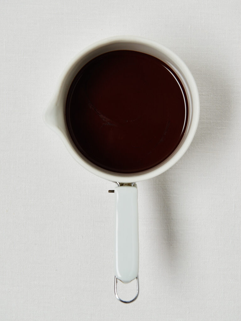 Drei Schritte zur Fudge-Basis: Schokodrops in einem Messbecher, geschmolzene Schokolade und geschmolzene Schokolade mit Erdnussmus.