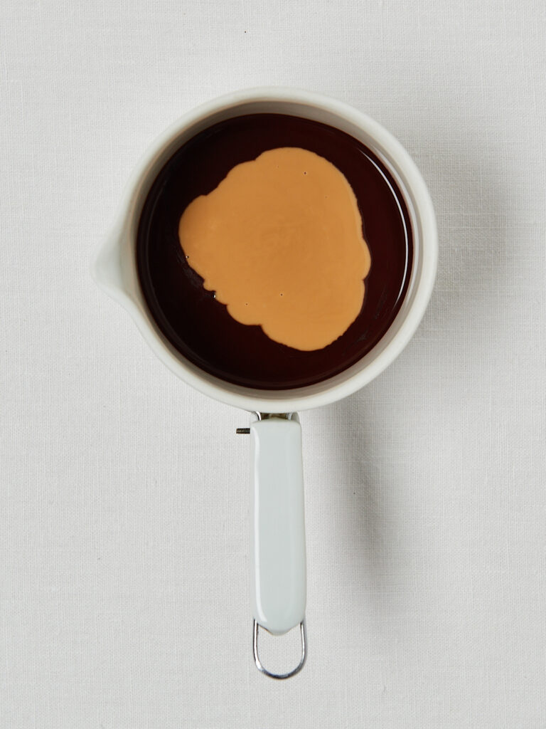 Drei Schritte zur Fudge-Basis: Schokodrops in einem Messbecher, geschmolzene Schokolade und geschmolzene Schokolade mit Erdnussmus.