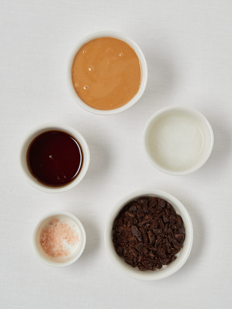 white bowls with ingredients: peanut butter, coconut oil, chocolate, vanille