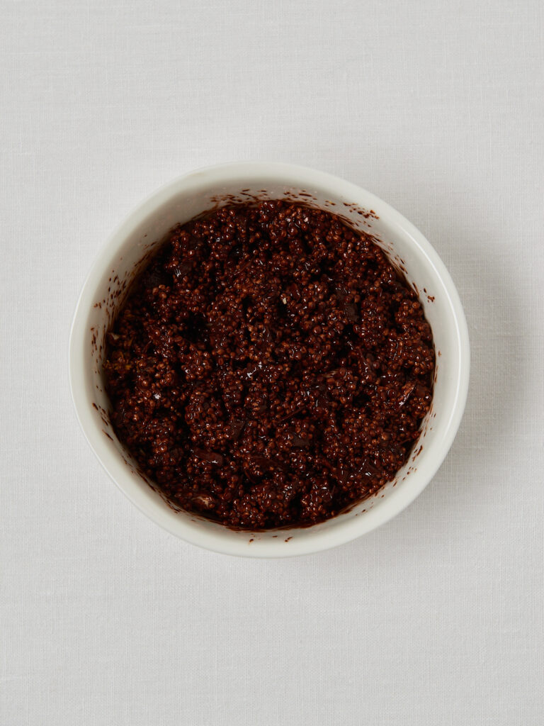 small white bowl with chocolate quinoa orange zest and almonds