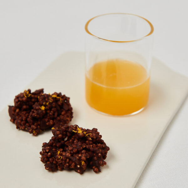 two chocolate crunch bites with quinoa and a glass of orange juice