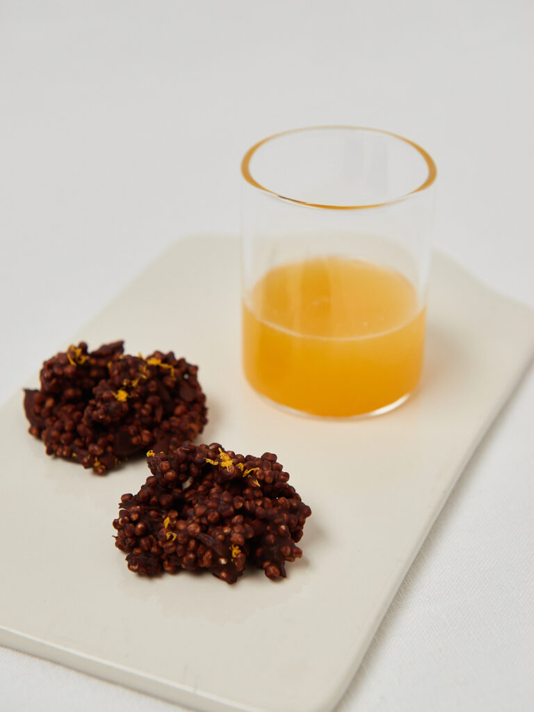 two chocolate crunch bites with quinoa and a glass of orange juice 