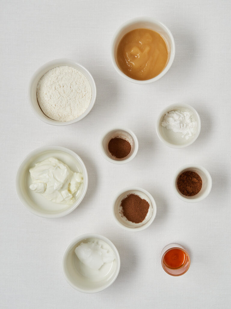 smal white bowls with ingredients apple sauce, yogurt, cinnamin, coconut oil, flour