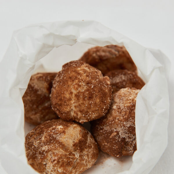 apple munchkins with cinnamon sugar in white paper bag