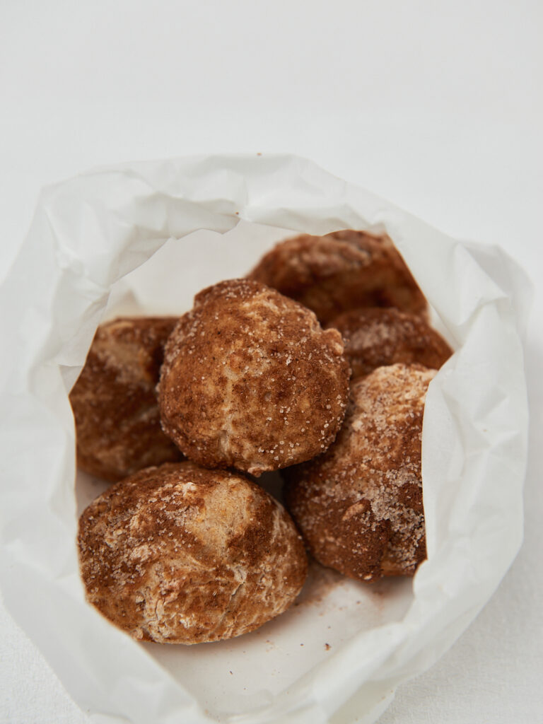 apple munchkins with cinnamon sugar in white paper bag