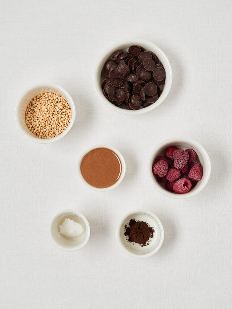 Zutaten für Schoko Himbeer Kuesschen mit Kakao, Himbeeren und Schokodrops von oben