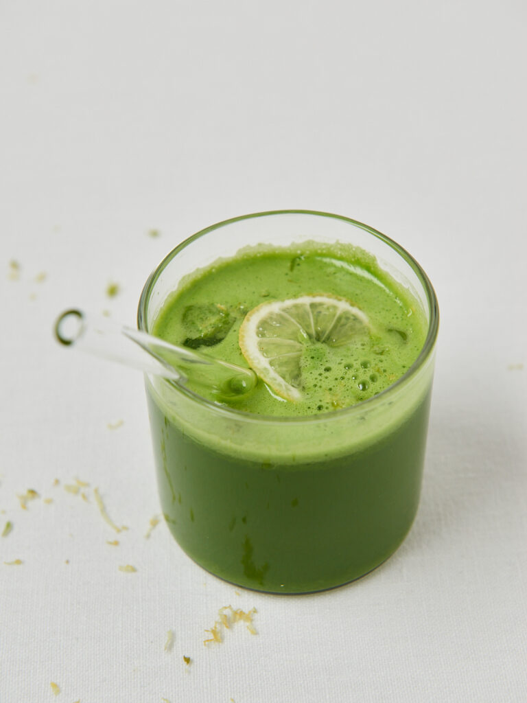 green juice in a glass with glass straw