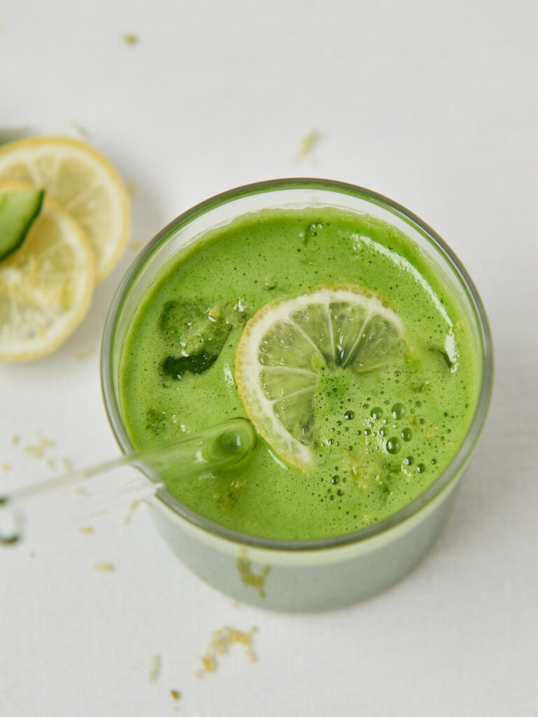 Gr&uuml;ne Smoothie-Zutaten im Mixer von oben, Gr&uuml;ner Detox-Smoothie mit Zitrone und Gurke im Glas
