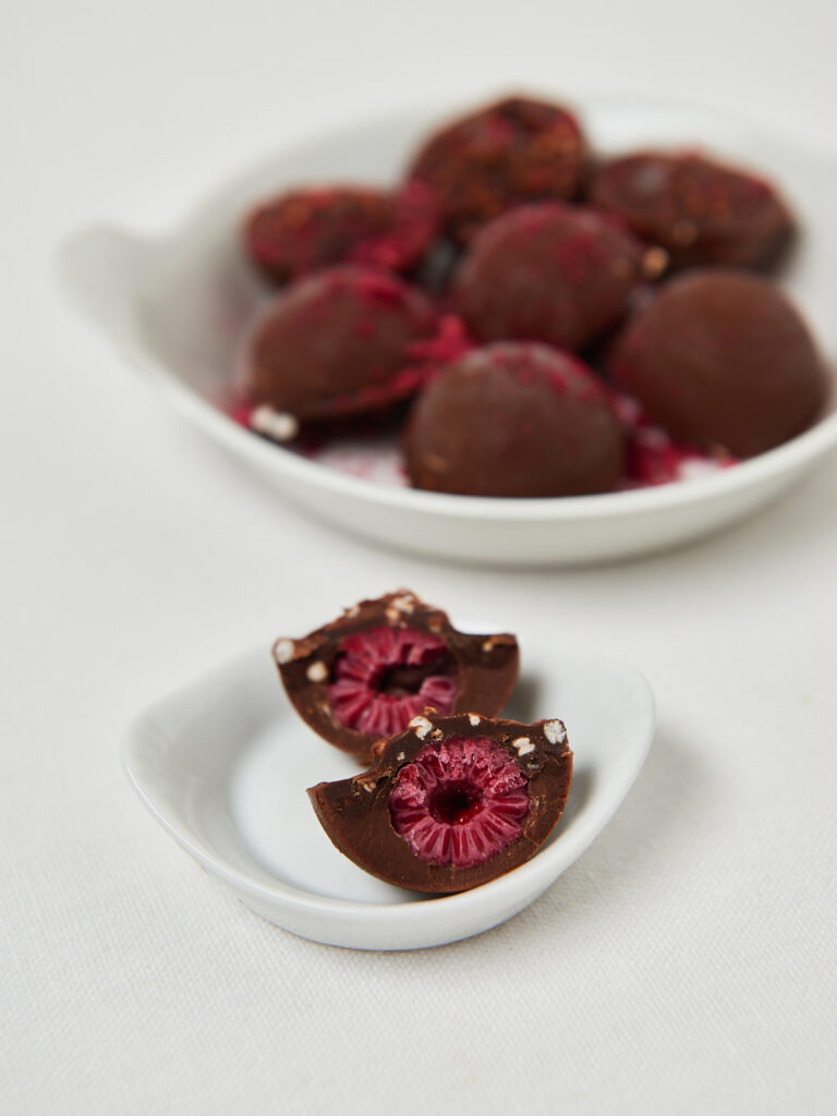 Gesunde Schoko-Snacks mit Himbeeren, angerichtet in Keramikschale