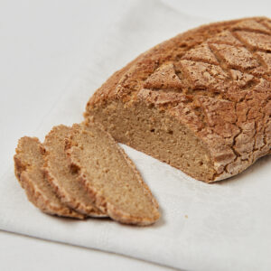 Laib Brot in Scheiben geschnitten auf hellem Untergrund