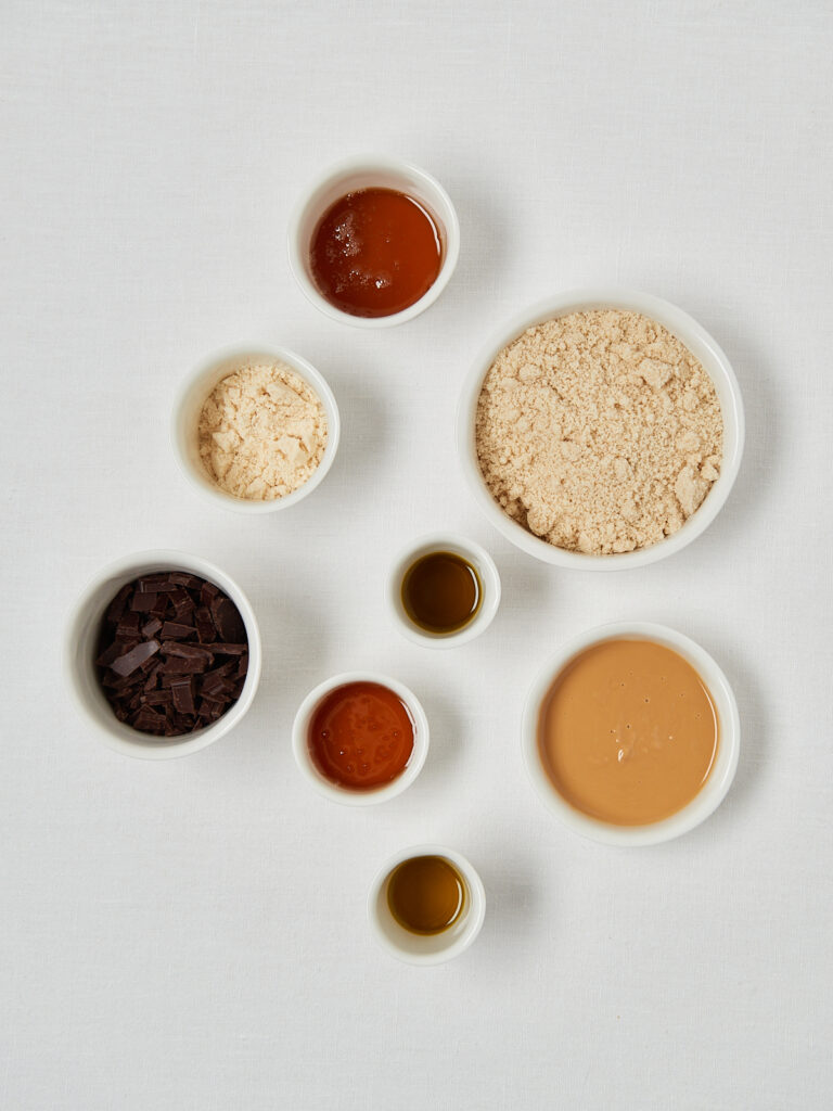 Detailaufnahme Peanut-Butter-Schoko-Snack Zutaten in weissen Schüsseln , homemade und natürlich