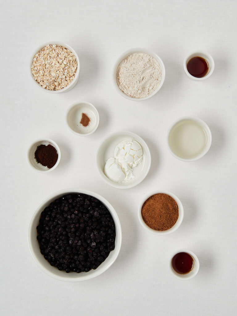 Zutatenübersicht für gesunden Beeren-Crumble auf hellem Hintergrund