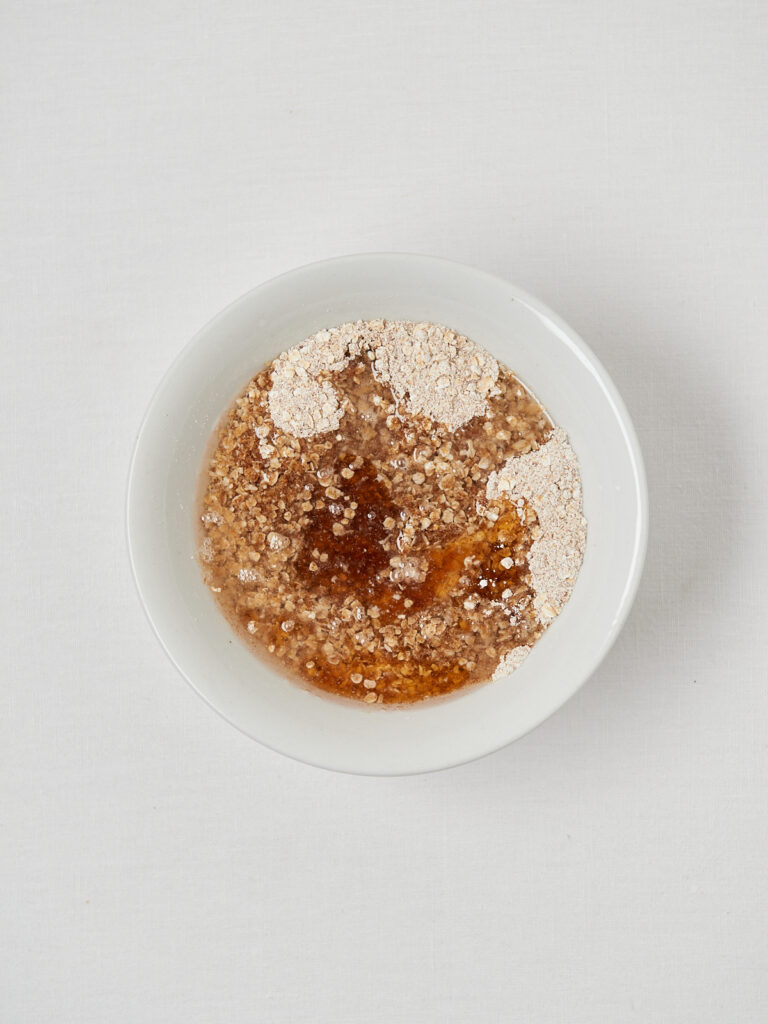 Crumble-Zutaten in Schüssel vor dem Vermengen
Trockene Crumble-Mischung aus Haferflocken und Nüssen
Mehl- und Zimt-Mischung für gesunden Crumble