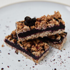 Gebackener Beeren-Crumble-Riegel in Backform auf weissem Teller