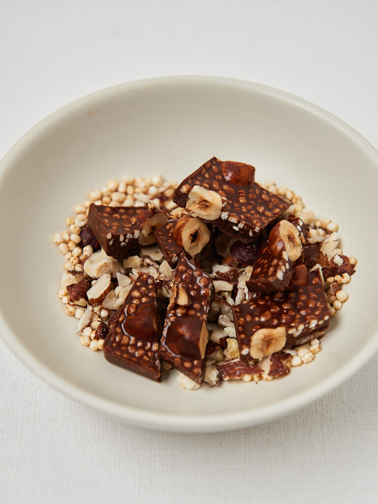 Knusprige Schokoladenriegel auf Nuss-Topping, minimalistisches Foodstyling