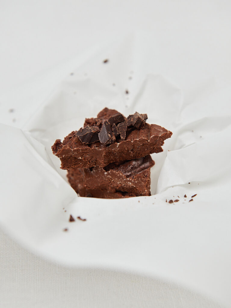 High-protein chocolate brownies scattered with dark chocolate shavings