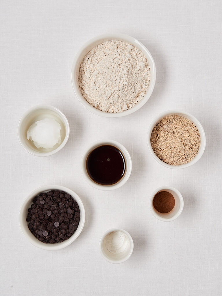 Zutaten fuer Haselnuss Schoko Cookies in weissen Schuesselchen