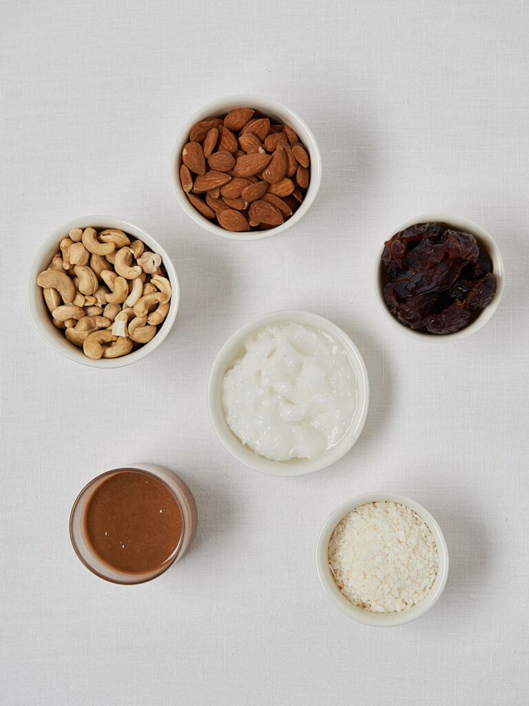 Flatlay of ingredients for coconut protein balls including nuts and dates