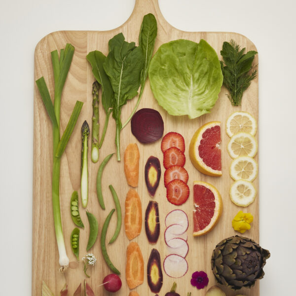 Auswahl an saisonalem Gemüse und Obst auf Holzbrett, natürlich und unverarbeitet.