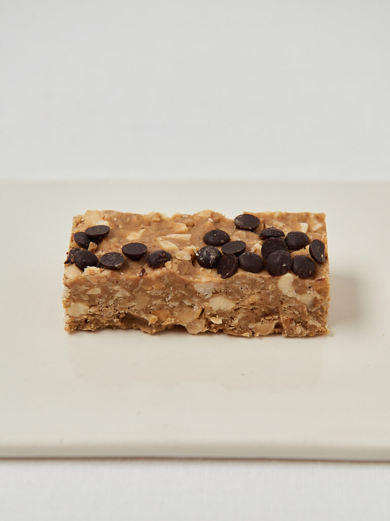 Single protein granola bar on white background, healthy snack idea