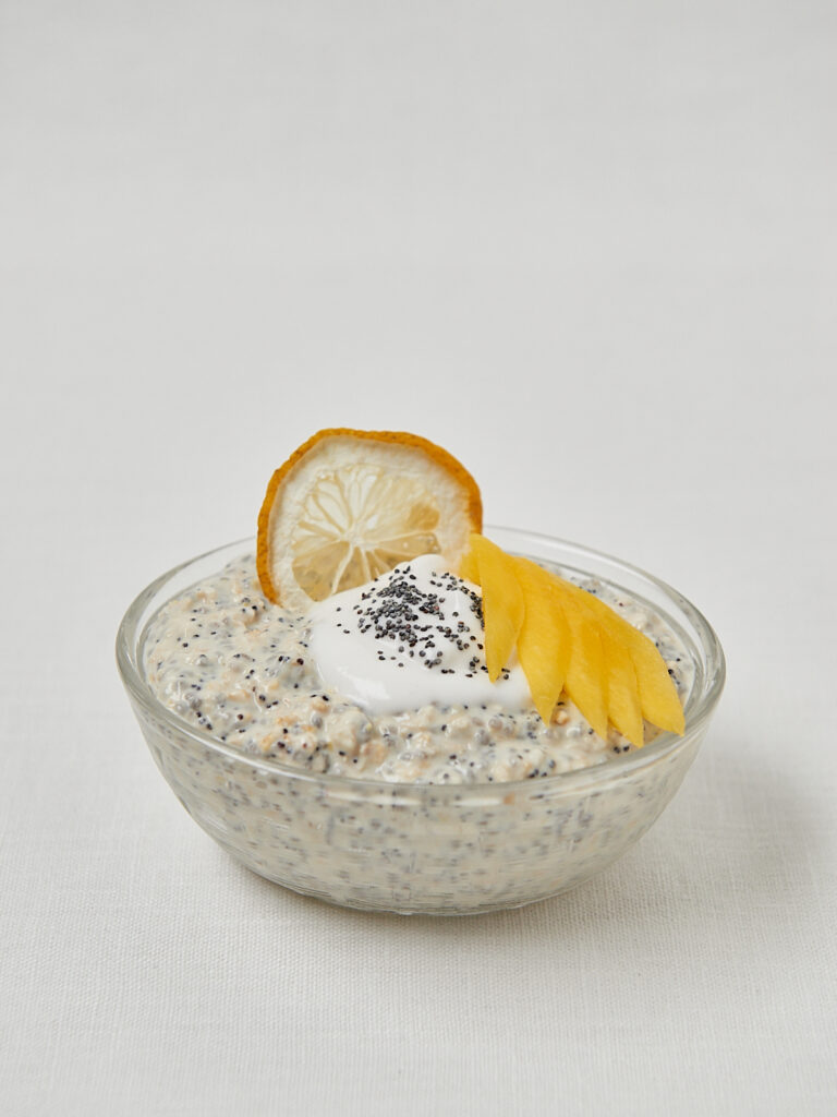 Overnight Oats mit Zitronenscheibe und Joghurt-Topping in Glassch&uuml;ssel, sommerliches Fr&uuml;hst&uuml;ck