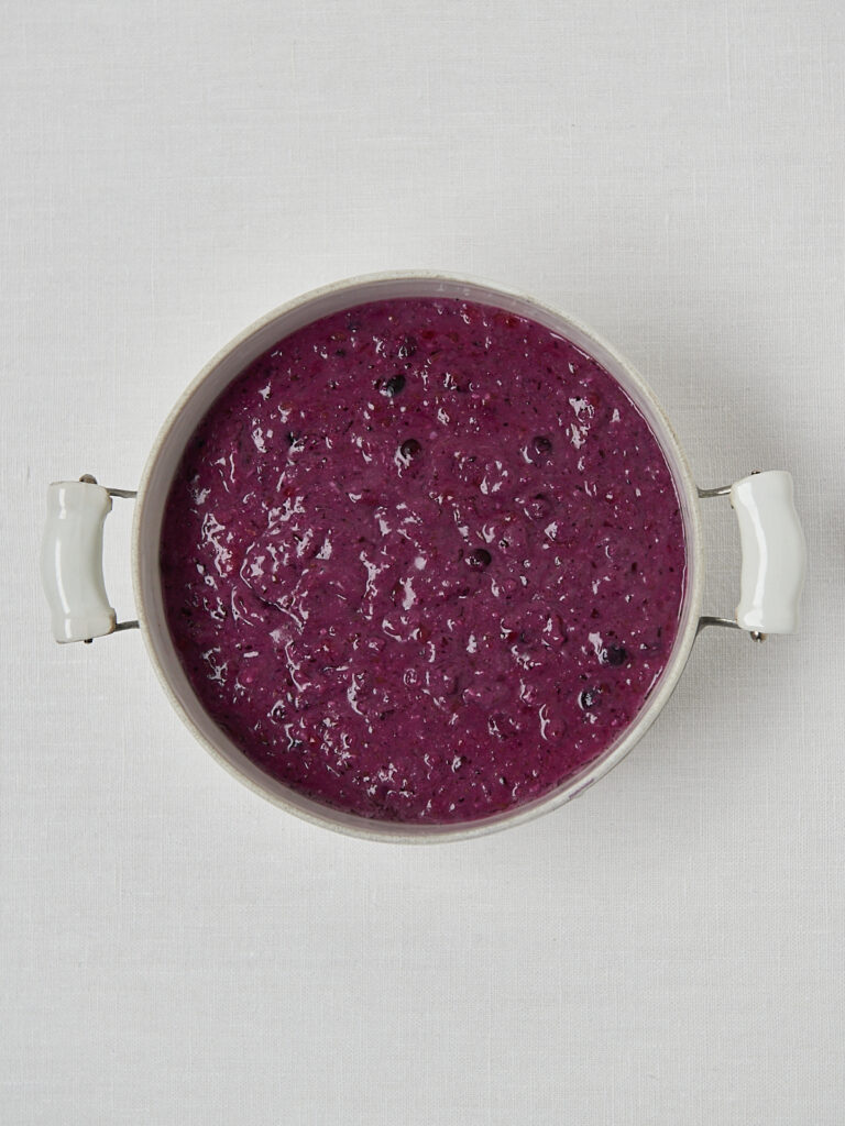 Einfaches Beeren-Porridge in wei&szlig;em Topf ohne Topping &ndash; minimalistische Draufsicht