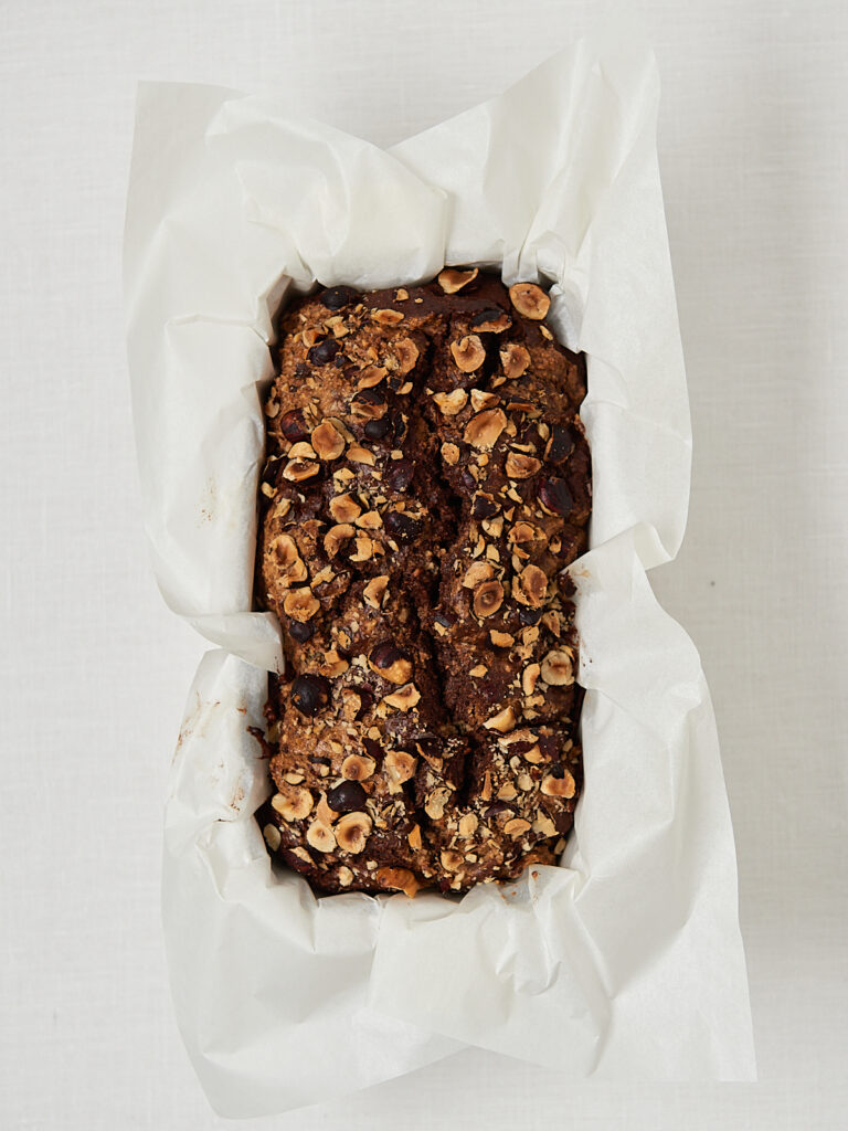 Low Carb Nusskuchen in Backpapier in Kastenform, frisch gebacken, Draufsicht