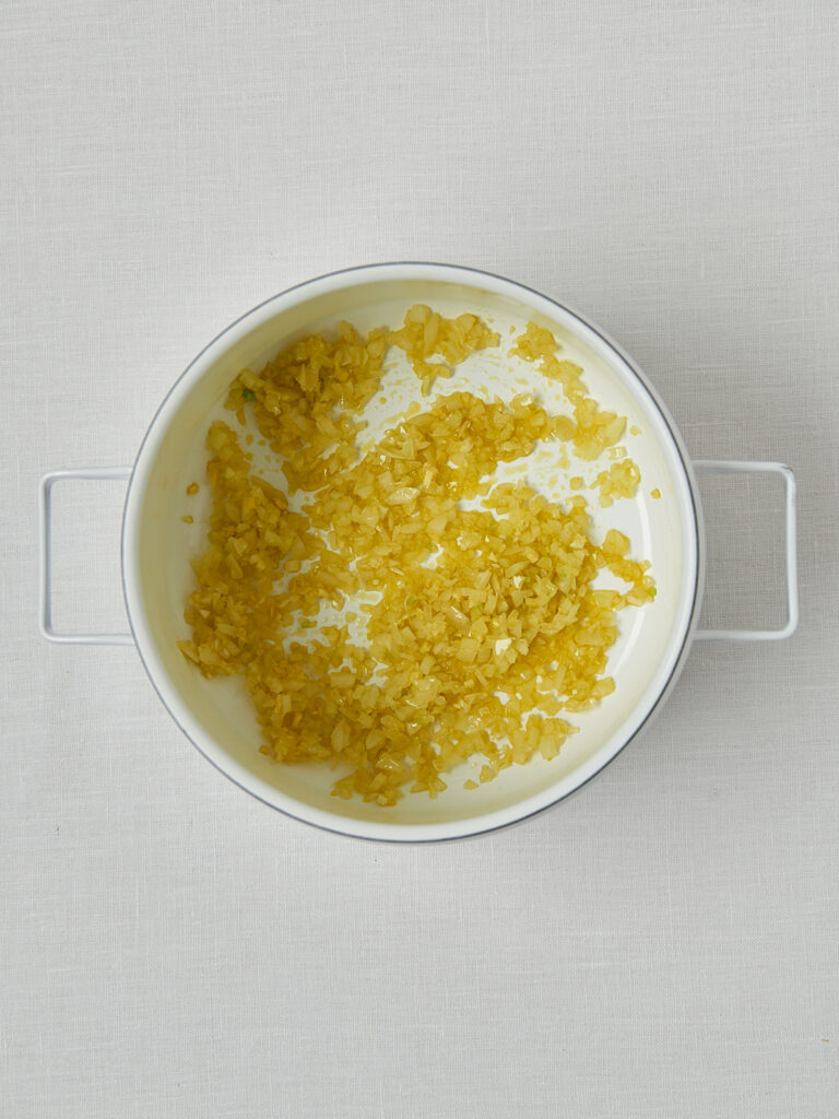 Zwiebeln in Butter anged&uuml;nstet in wei&szlig;er Sch&uuml;ssel &ndash; Zubereitung Linsensuppe