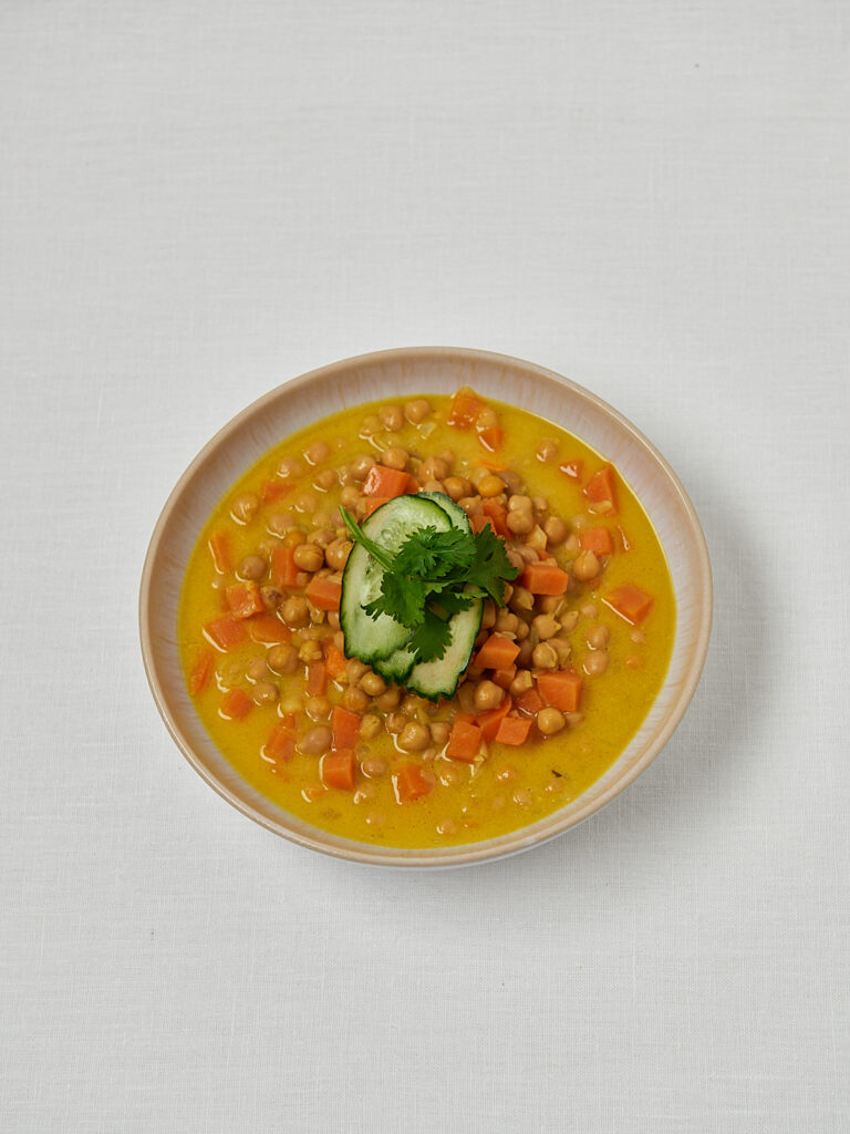 Cremige Linsensuppe mit Koriander, Limette und Kokosjoghurt in wei&szlig;er Schale