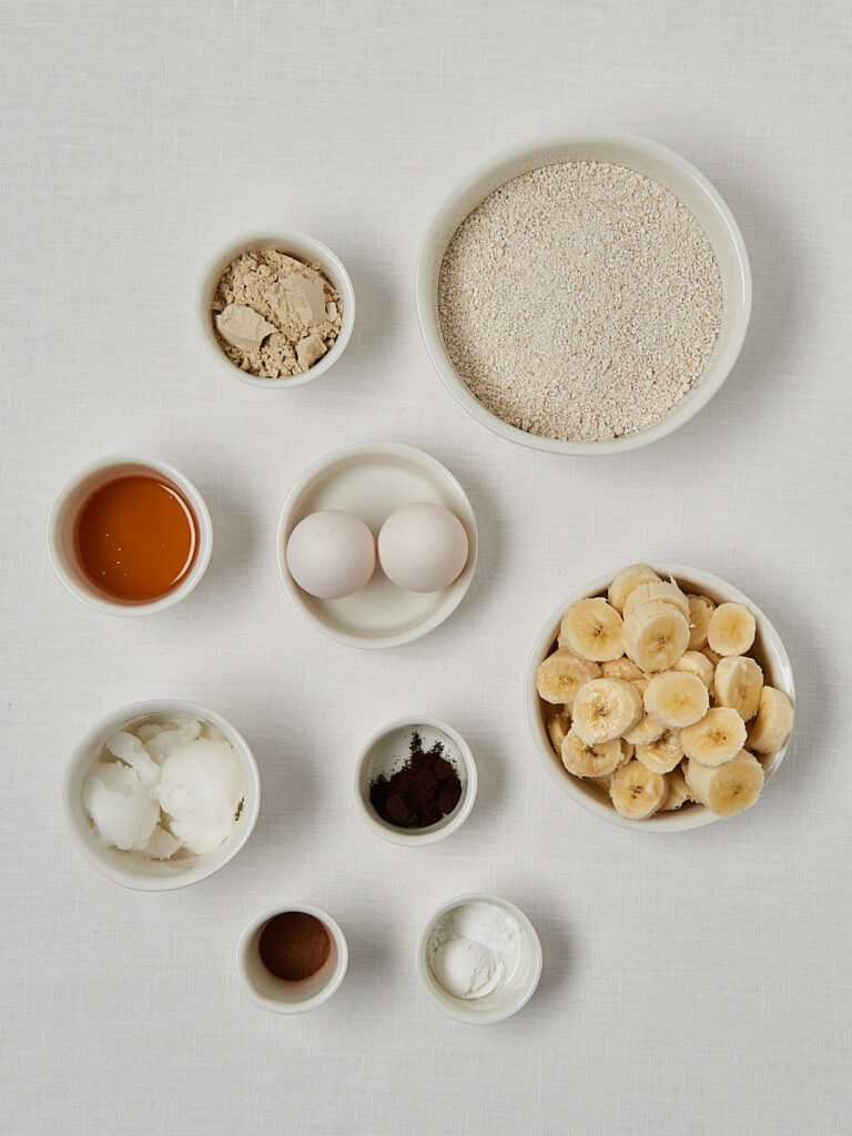 Zutaten-Flatlay Protein Banana Bread – Hafermehl, Eier, Honig und Backzutaten von oben