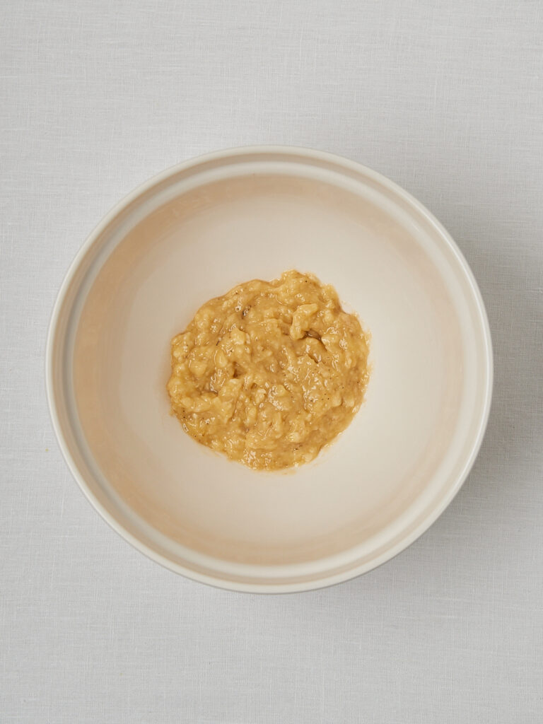 Zerdrückte Bananen in weißer Schüssel – Basis für gesundes Bananenbrot Rezept