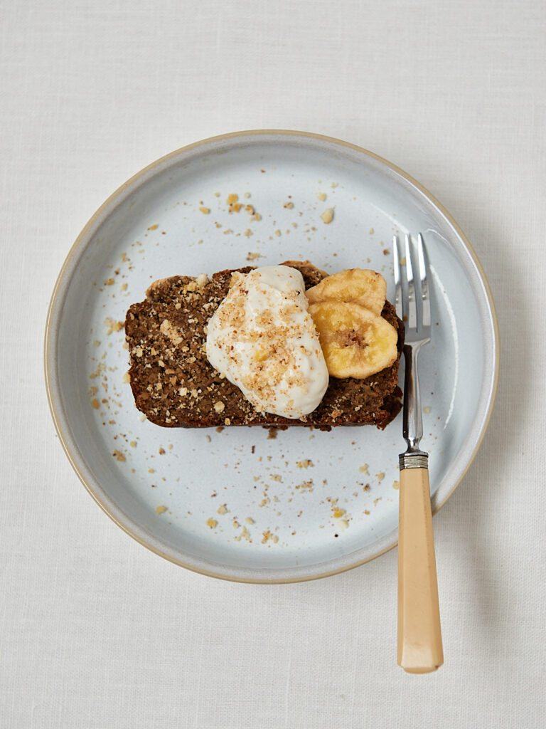 Protein Banana Bread mit frischer Banane als Topping &ndash; Draufsicht auf grauem Teller
