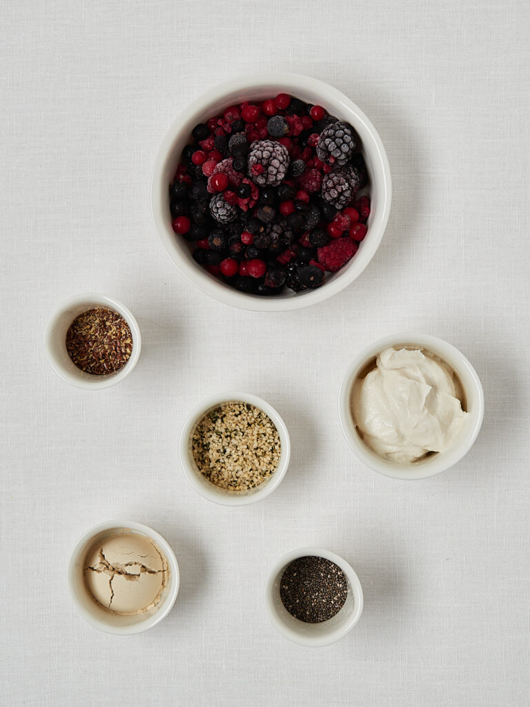 Overhead Flatlay Super Power Shake Zutaten mit Beeren, Chiasamen, Leinsamen