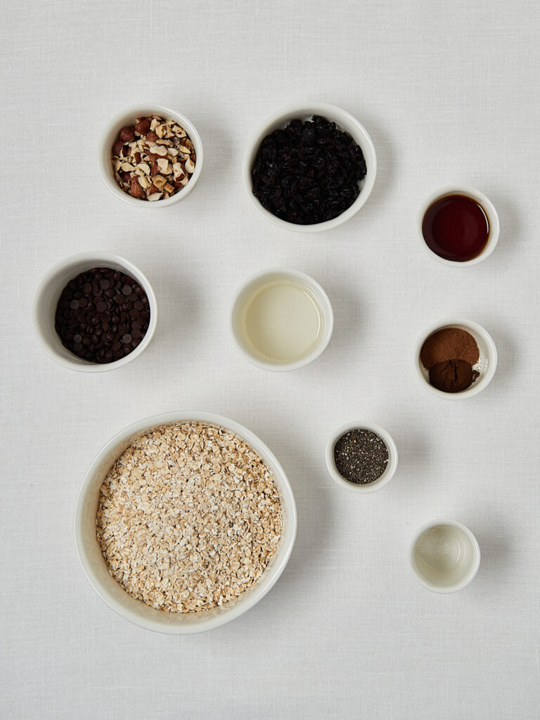 Zutaten-Flatlay Cherry Chocolate Granola &ndash; Haferflocken, N&uuml;sse, Kirschen, Schokolade und Gew&uuml;rze