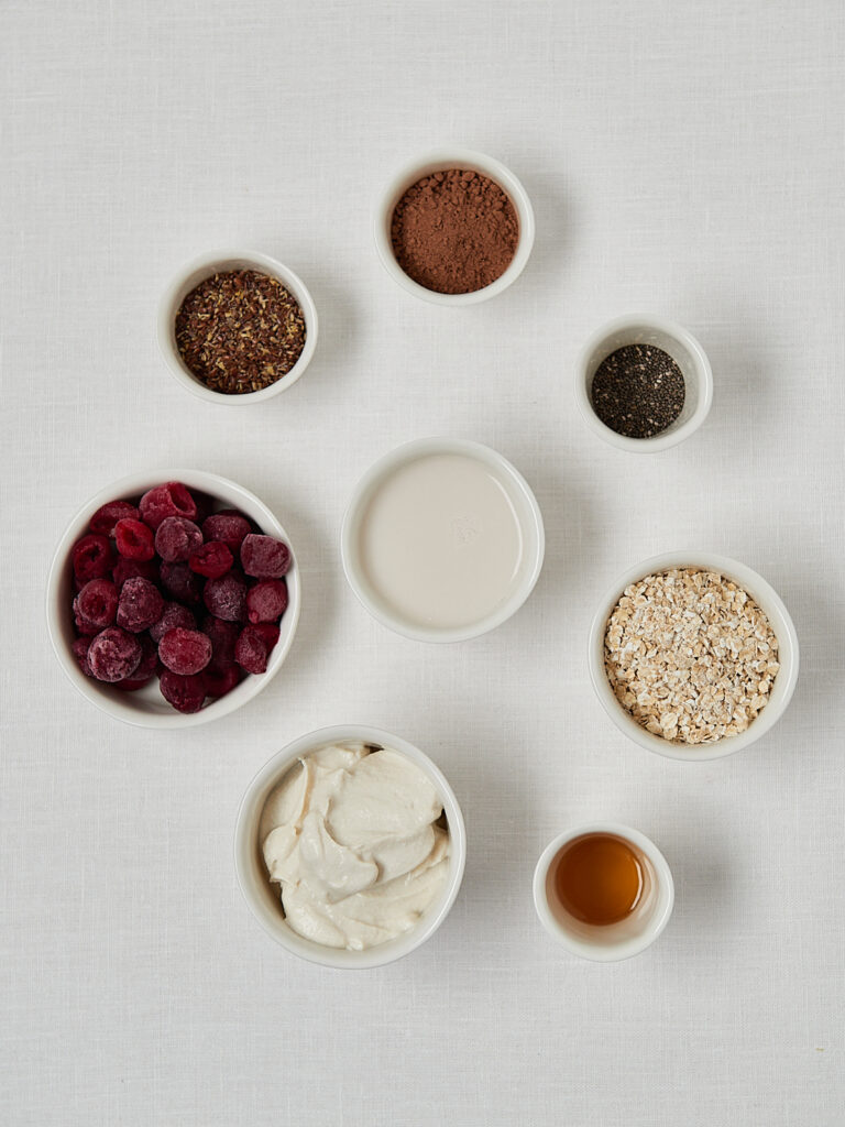 Zutaten-Flatlay Schoko-Kirsch Overnight Oats &ndash; Kakaopulver, Chiasamen, Joghurt, Kirschen und Ahornsirup