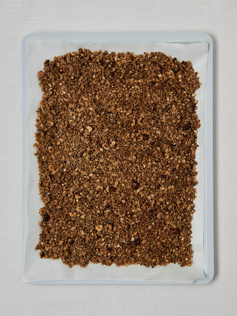Granola auf Backpapier ausgebreitet &ndash; gleichm&auml;&szlig;ige Schicht vor dem Backen