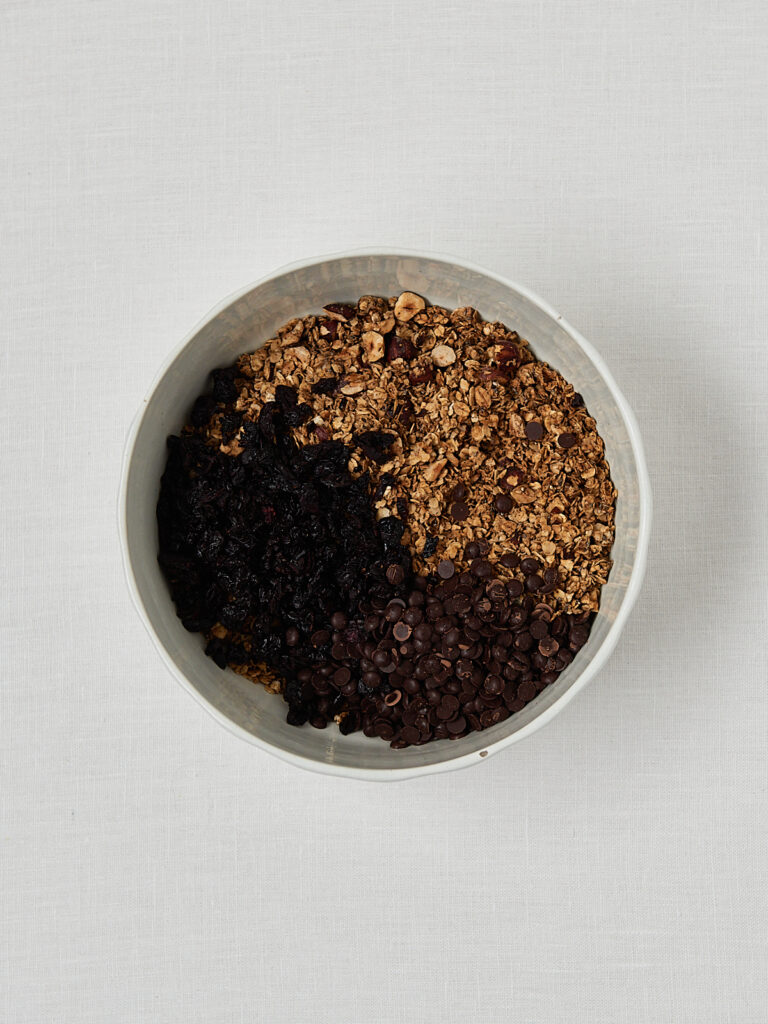 Dunkle Granola-Masse im Sch&auml;lchen vor dem Backen &ndash; Zubereitung Cherry Granola