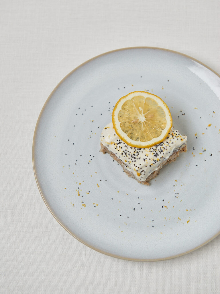 Baked Oats mit Zitrone und Mohn-Topping auf rundem Teller – Overhead Shot