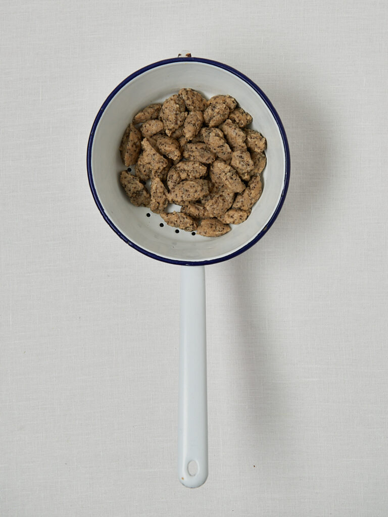 Rohe Haferflocken Gnocchi in blauem Topf mit Wasser – Zubereitung Schritt