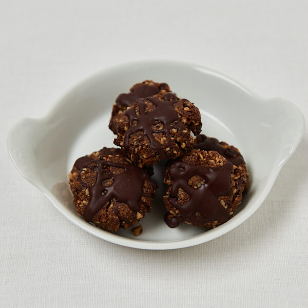 Omega Power Date Walnut Cookies auf weißem Servierteller – ungebackene Portionen