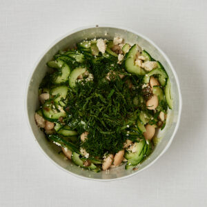 Gurken Bohnensalat mit frischem Dill in wei&szlig;er Sch&uuml;ssel &ndash; Zubereitungsschritt vor dem Vermengen