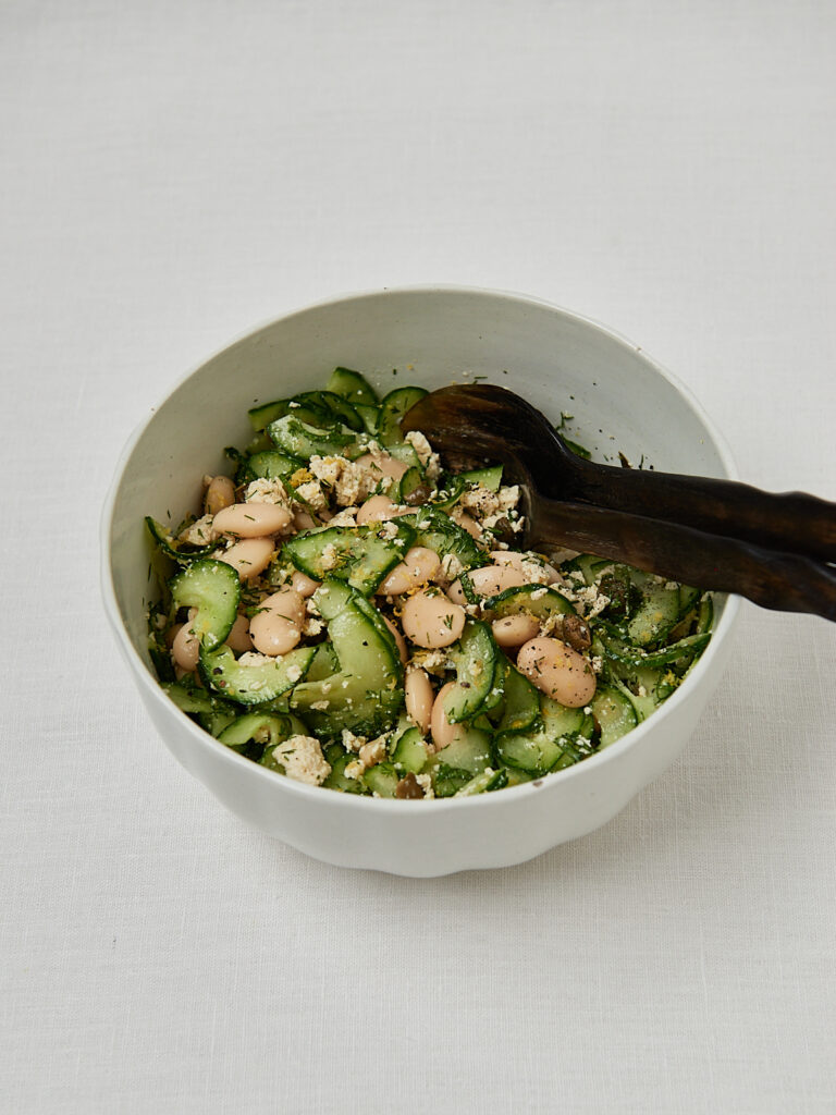 Gurken Feta Salat beim Vermengen mit K&uuml;chenzange &ndash; Zubereitungsschritt Overhead