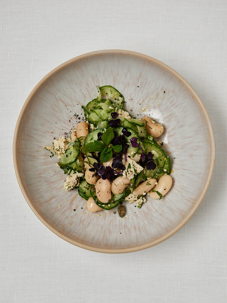 Gurken Bohnensalat mit Feta, Dill und Minze auf hellem Teller &ndash; Draufsicht